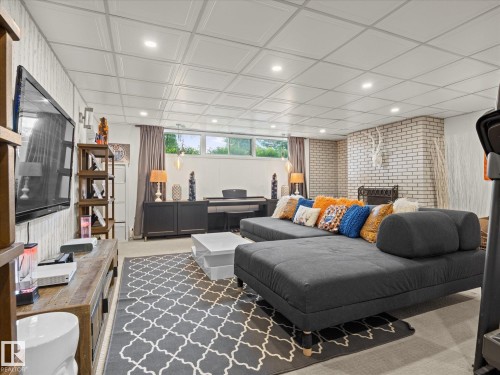 Expansive recreation room featuring a white brick fireplace, recessed lighting, and a drop ceiling - 8822 161 Street, Edmonton, AB 