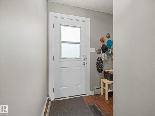 Entryway featuring a white door with upper glass panels, dark wood-finish flooring, and light gray walls - 8822 161 Street, Edmonton, AB 