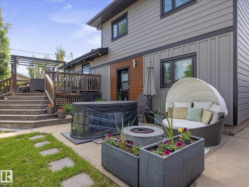 Backyard featuring a multi-level wood deck, concrete patio, and a built-in fire pit - 8822 161 Street, Edmonton, AB 