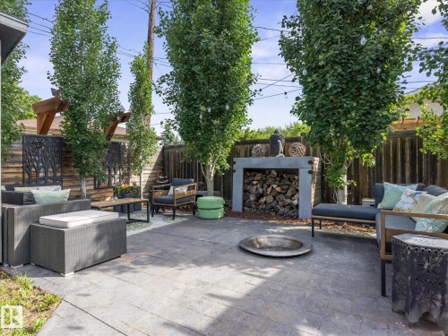 Expansive outdoor living area featuring a paver patio and a built-in wood storage unit - 8822 161 Street, Edmonton, AB 