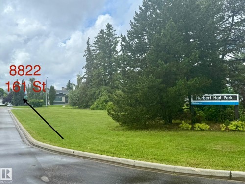 Expansive green space featuring a Herbert Hart Park sign and mature evergreen trees - 8822 161 Street, Edmonton, AB 