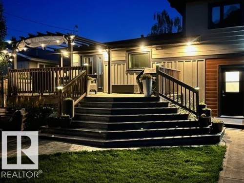 Multi-level wood deck with integrated lighting, glass-paneled double doors, and a pergola structure - 8822 161 Street, Edmonton, AB 