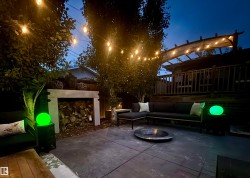 Stamped concrete patio featuring an outdoor sectional, fire pit, and string lighting - 