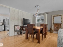 Dining area featuring light wood-finish flooring, a contemporary chandelier with clear glass globes, and a window with white trim - 