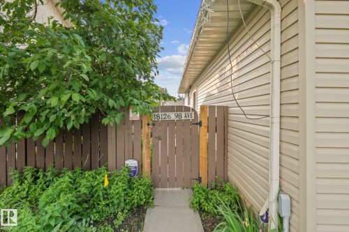 Private side yard access through a wooden gate with concrete pathway - 18126 98 Avenue, Edmonton, AB 