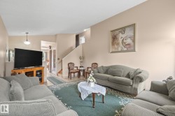 Spacious living area featuring light neutral wall tones and a ceiling-mounted light fixture - 