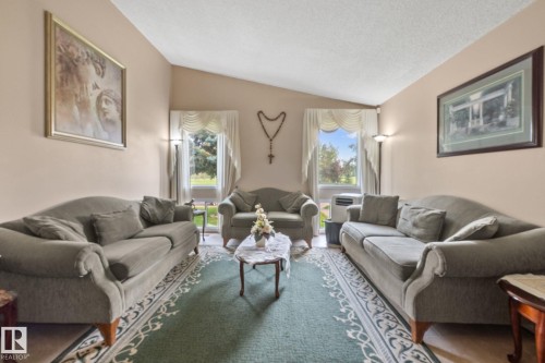 Living area featuring a vaulted ceiling and two large windows - 18126 98 Avenue, Edmonton, AB 