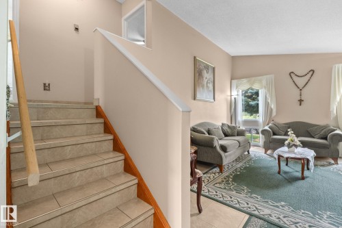 Tile staircase with natural wood handrail and trim - 18126 98 Avenue, Edmonton, AB 