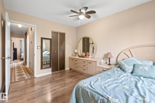 Bedroom featuring wood-finish flooring, a ceiling fan with integrated lighting, and a neutral wall color - 18126 98 Avenue, Edmonton, AB 