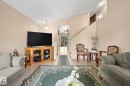 Vaulted ceiling living area with neutral wall tones, tile flooring, and a staircase - 18126 98 Avenue, Edmonton, AB 