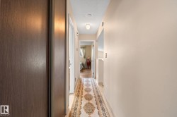 Hallway featuring wood-finish flooring, recessed lighting, and a neutral color palette - 