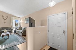Entry area featuring a paneled door with polished hardware, a decorative ceiling light fixture, and tile flooring - 