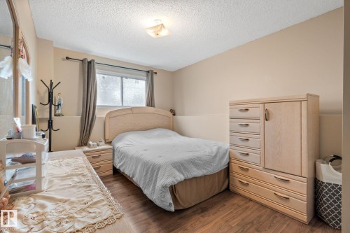 Bedroom featuring wood-finish flooring, a window with drapery, and neutral-toned walls - 18126 98 Avenue, Edmonton, AB 