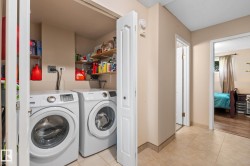 Dedicated laundry area featuring front-loading appliances and integrated shelving - 
