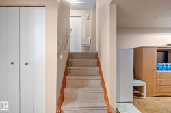 Tiled staircase featuring wood-finish handrail - 