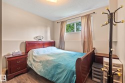 Bedroom featuring wood-finish flooring, a double-hung window, and a built-in ceiling light fixture - 