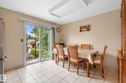 Dining area featuring tile flooring, neutral wall paint, and a large sliding glass door - 