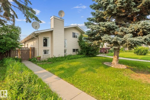 Two-story property featuring light-colored siding and an exterior chimney structure - 18126 98 Avenue, Edmonton, AB 
