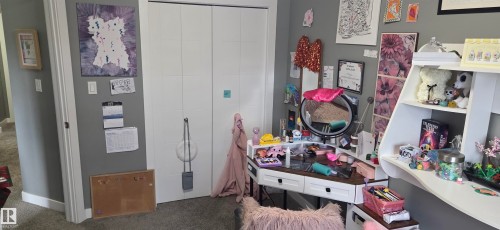 Carpeted room featuring a double-door closet with white panels - 16505 133 Street, Edmonton, AB 