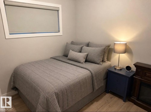 Light-toned walls complement wood-finish flooring in this room - 16505 133 Street, Edmonton, AB 