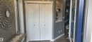 Entryway featuring a bi-fold closet, recessed wall niche, and wood-finish flooring - 16505 133 Street, Edmonton, AB 