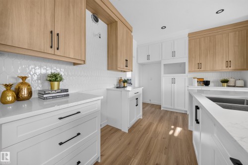 Modern kitchen featuring two-tone cabinetry with wood-finish and white shaker-style doors - 523 Ashgrove Circle, Leduc, AB 