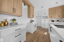 Modern kitchen featuring two-tone cabinetry with wood-finish and white shaker-style doors - 