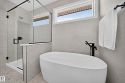 Freestanding soaking tub with a floor-mounted matte black faucet - 