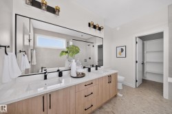Bathroom featuring a dual vanity with light wood-finish cabinetry, white countertops, and integrated rectangular sinks - 