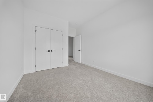 Neutral-toned wall-to-wall carpeting complements bright white walls and trim - 523 Ashgrove Circle, Leduc, AB 