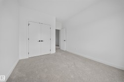 Neutral-toned wall-to-wall carpeting complements bright white walls and trim - 