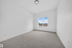 Room featuring light gray carpet flooring, white painted walls, a double-paned window with white trim, and a flush-mount ceiling light fixture - 