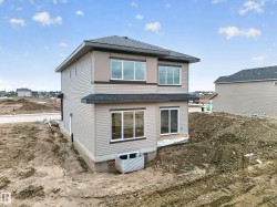 Contemporary two-story residence featuring light beige siding and dark brown trim accents - 
