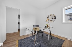 Room featuring light wood-finish flooring, white walls, and a window with white trim - 