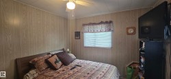 Interior room featuring light wood-panel walls and a ceiling fan with integrated lighting - 