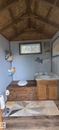 Vaulted wood-finish ceiling, light gray wall paneling, and a wood-framed window - 