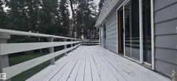 Expansive exterior deck featuring a painted wood surface and perimeter railing - 