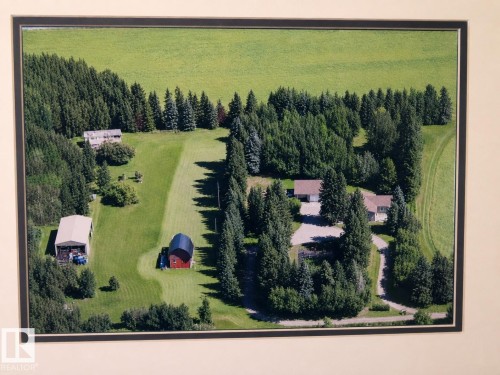 Expansive property featuring a primary residence with an attached garage, a secondary residence, a large open-sided outbuilding, and a red barn structure - 163062 Twp Rd 565, Rural Lamont County, AB 