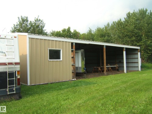 Metal-sided outbuilding featuring a covered open-air section, a fully enclosed section with a window, and a durable metal roof - 163062 Twp Rd 565, Rural Lamont County, AB 