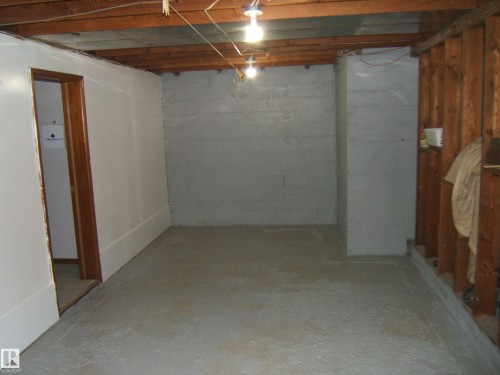 Spacious unfinished basement offering concrete flooring, exposed ceiling joists, concrete block walls, and an open stud wall - 163062 Twp Rd 565, Rural Lamont County, AB 