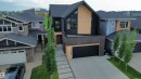 Contemporary exterior design featuring dark siding, light wood-finish accents, and a prominent peaked roofline - 104 Edgewater Circle, Leduc, AB 