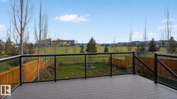 Spacious exterior deck with composite decking and contemporary glass panel railing - 