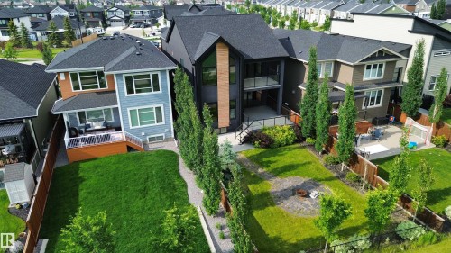 Modern home featuring a multi-level design with dark siding and wood-accent panels - 104 Edgewater Circle, Leduc, AB 