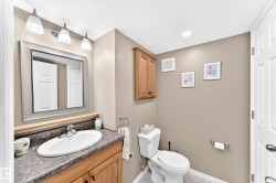 Bathroom vanity with wood cabinetry, an undermount sink, and a speckled countertop - 