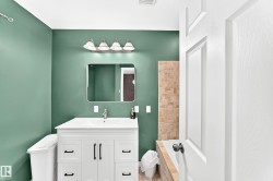 White vanity with black hardware, rectangular undermount sink, and brushed nickel faucet - 