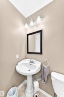 Pedestal sink with chrome faucet set, framed mirror, and three-light vanity fixture - 