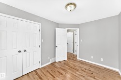 Interior room featuring wood-finish flooring, light gray wall paint, and white trim - 