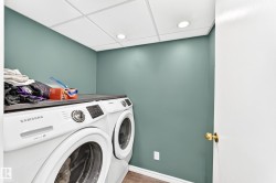 Dedicated laundry area featuring a countertop surface above side-by-side appliances, recessed ceiling lighting, and wood-finish flooring - 