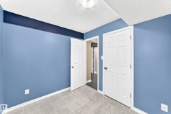 Room featuring light blue walls with a dark blue accent band, neutral-toned tiled flooring, white trim, and a textured ceiling - 
