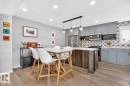 Open Concept Dining Room Space featuring Stylish Lighting, Kitchen Bar Space, and Accent Tiles. - 1051 Cy Becker Road, Edmonton, AB 